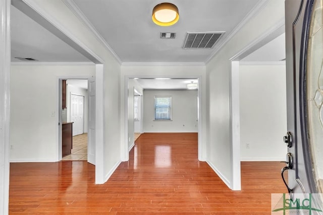 entryway featuring visible vents, wood finished floors, and ornamental molding