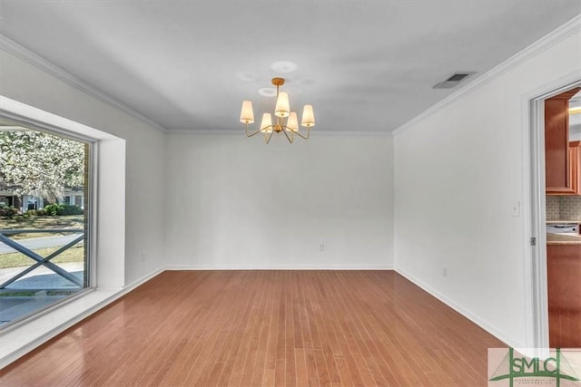 spare room featuring an inviting chandelier, visible vents, and ornamental molding