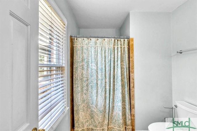 full bathroom with a shower with curtain and toilet