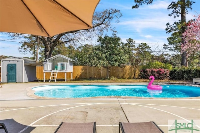 view of swimming pool with a storage unit, an outbuilding, fence, a fenced in pool, and a patio area