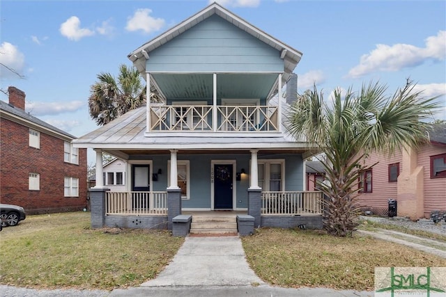 view of front of house featuring a balcony, a porch, and a front lawn