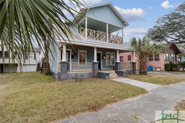 view of front of house featuring a balcony, a porch, and a front yard