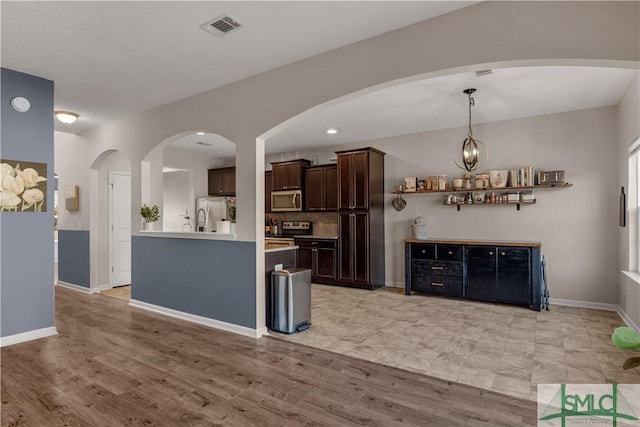 kitchen with visible vents, stainless steel appliances, light countertops, baseboards, and dark brown cabinets