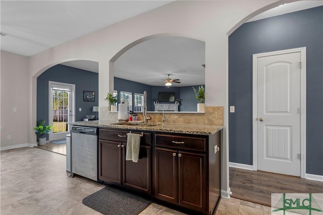 kitchen featuring baseboards, light stone countertops, dark brown cabinetry, and dishwasher