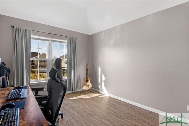 office space with vaulted ceiling, baseboards, and wood finished floors