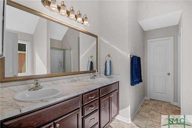 full bath featuring a sink, an enclosed shower, baseboards, and double vanity