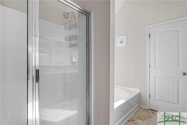 bathroom with a stall shower and a garden tub