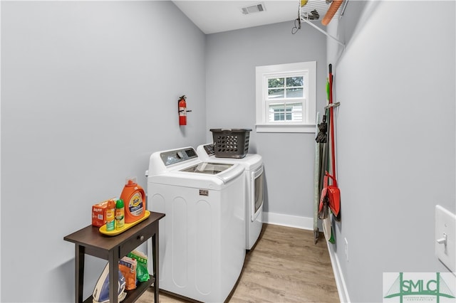 laundry room with visible vents, baseboards, laundry area, light wood-style flooring, and independent washer and dryer