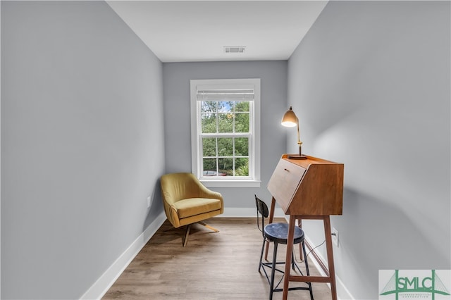 sitting room with visible vents, baseboards, and wood finished floors