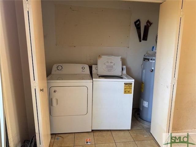 washroom featuring light tile patterned floors, electric water heater, laundry area, and washer and clothes dryer