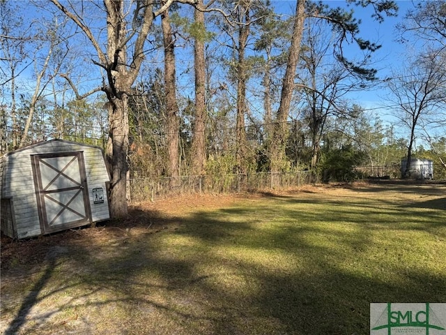 view of yard featuring an outbuilding, a storage shed, and fence