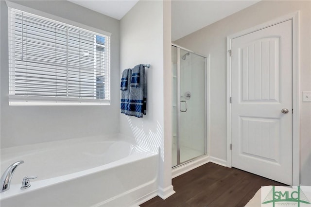 full bathroom with wood finished floors, a garden tub, and a stall shower