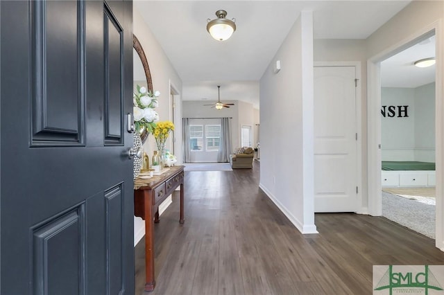 foyer featuring dark wood-type flooring, baseboards, and ceiling fan