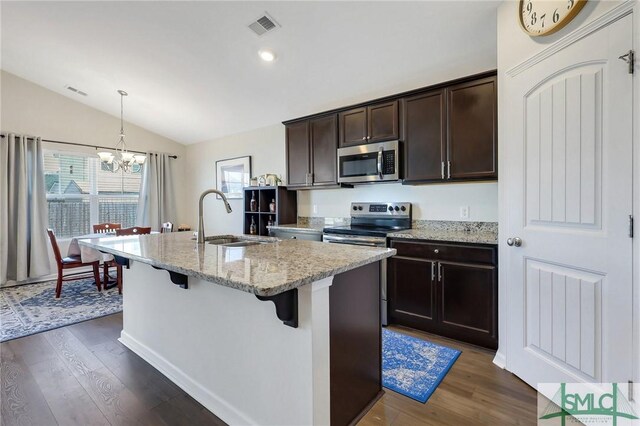 kitchen with visible vents, an inviting chandelier, a sink, vaulted ceiling, and appliances with stainless steel finishes