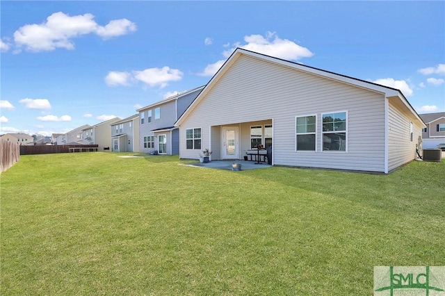 rear view of property featuring a lawn, cooling unit, a patio, and fence