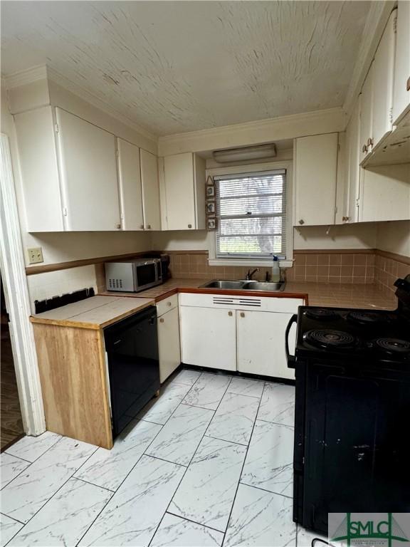 kitchen featuring ornamental molding, a sink, black appliances, white cabinets, and marble finish floor