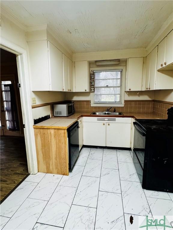 kitchen featuring marble finish floor, white cabinetry, black appliances, and a sink