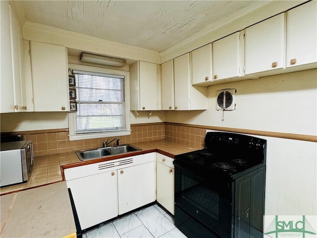 kitchen featuring white cabinetry, stainless steel microwave, black range with electric stovetop, and a sink