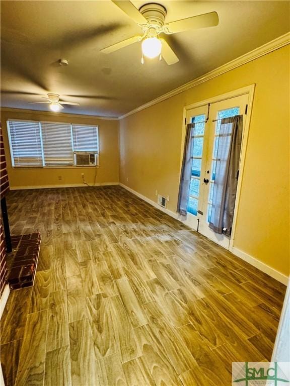 spare room featuring wood finished floors, baseboards, ornamental molding, ceiling fan, and french doors