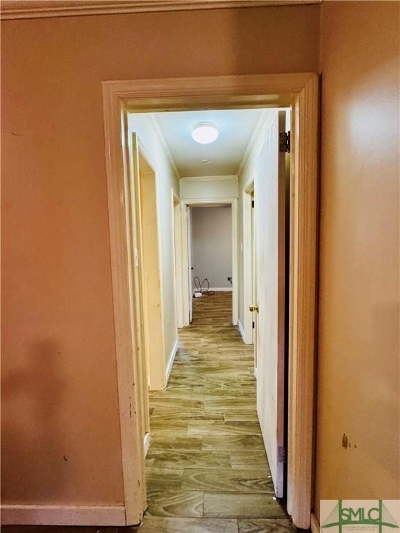 hall with wood finished floors, baseboards, and ornamental molding