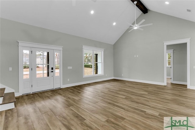 unfurnished living room with a ceiling fan, wood finished floors, baseboards, high vaulted ceiling, and beamed ceiling