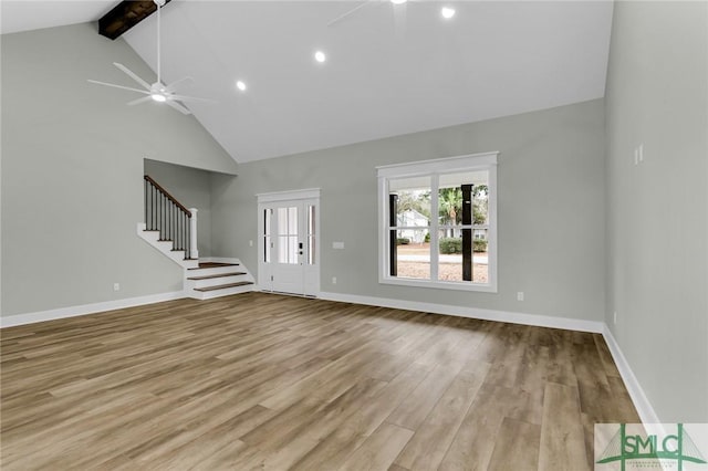 unfurnished living room featuring baseboards, stairs, beam ceiling, wood finished floors, and a ceiling fan