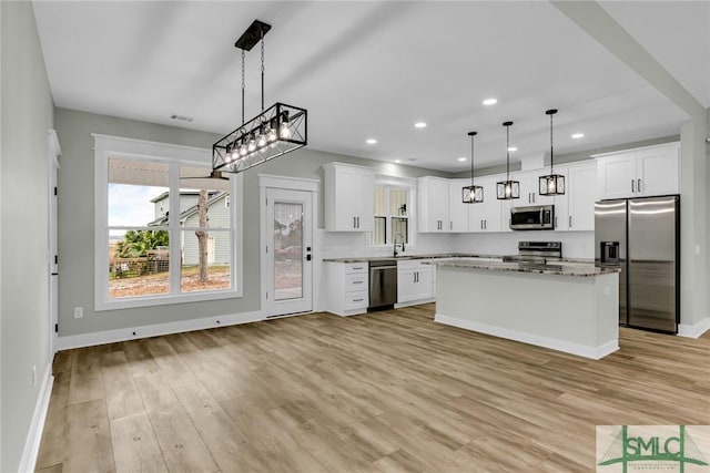 kitchen featuring recessed lighting, stainless steel appliances, light wood-style floors, white cabinetry, and a sink