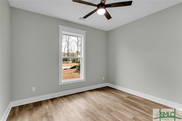 spare room with visible vents, wood finished floors, baseboards, and ceiling fan