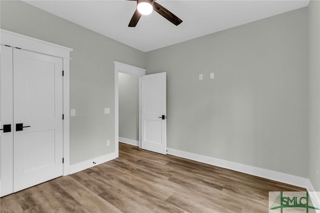 unfurnished bedroom featuring wood finished floors, baseboards, and ceiling fan