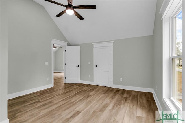 interior space with baseboards, lofted ceiling, wood finished floors, and a ceiling fan