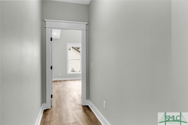 hallway with wood finished floors and baseboards