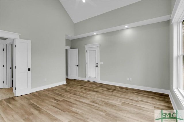 unfurnished bedroom featuring recessed lighting, baseboards, light wood finished floors, and high vaulted ceiling