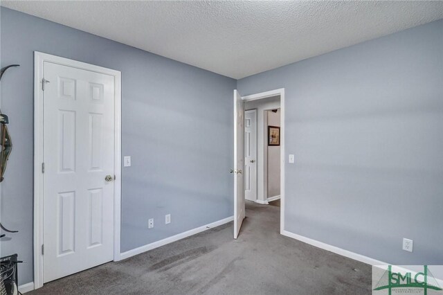 unfurnished bedroom with baseboards, carpet flooring, and a textured ceiling