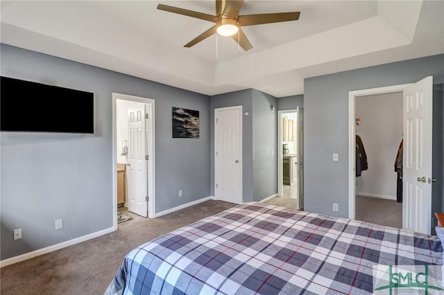 bedroom featuring carpet flooring, baseboards, a raised ceiling, and a closet