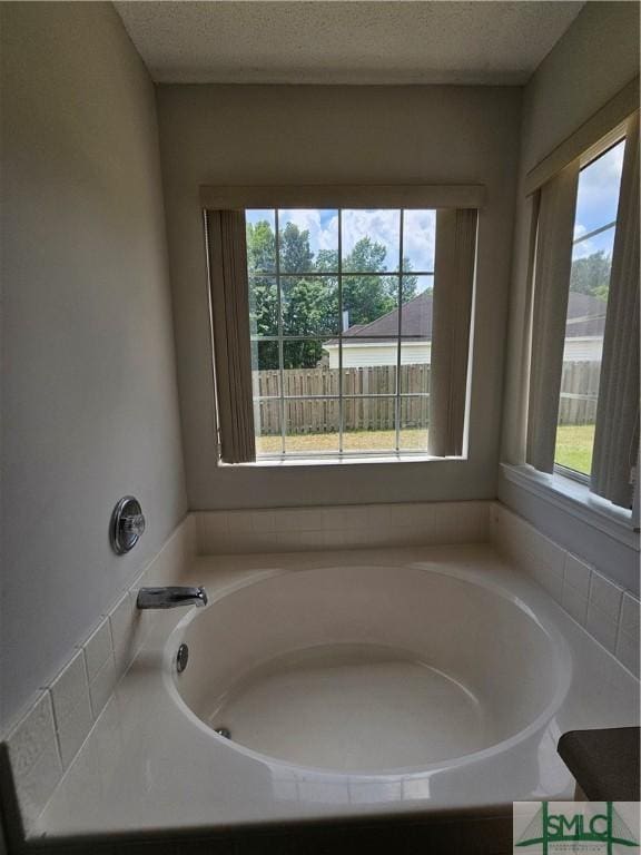 bathroom featuring a textured ceiling and a bath