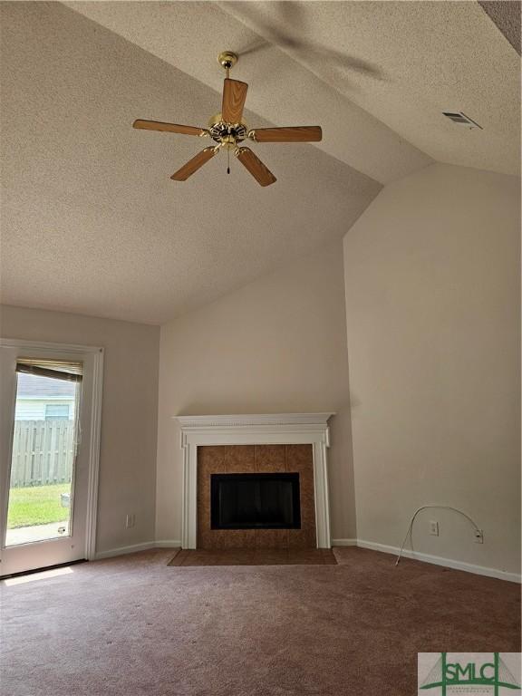 unfurnished living room featuring carpet flooring, a fireplace, a textured ceiling, lofted ceiling, and visible vents
