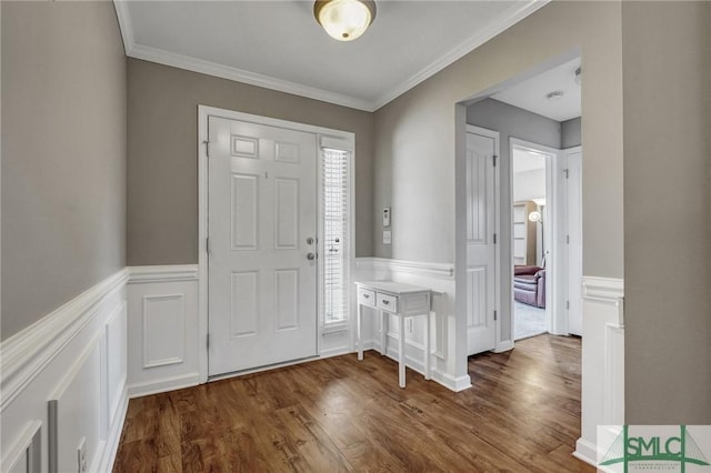 foyer entrance with dark wood-style floors, a wealth of natural light, and ornamental molding