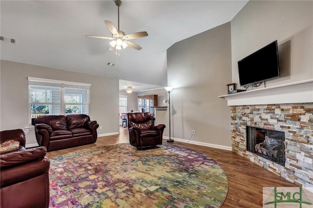 living room featuring a fireplace, wood finished floors, visible vents, and ceiling fan