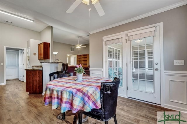 dining space with visible vents, ceiling fan, and wood finished floors