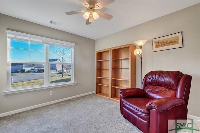 sitting room with carpet flooring, baseboards, visible vents, and ceiling fan