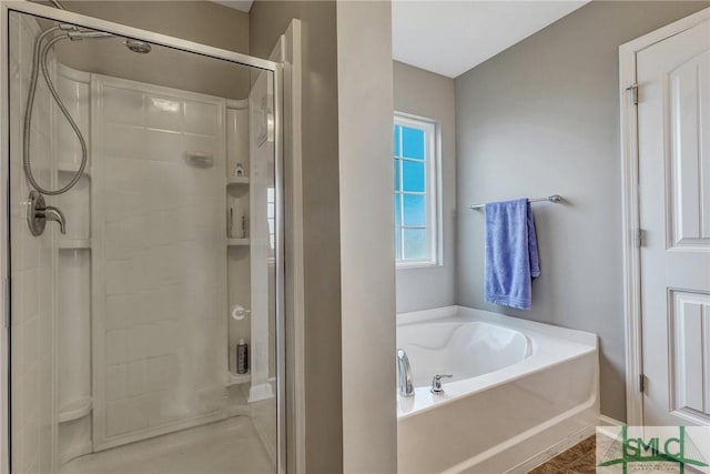 bathroom featuring a garden tub and a shower stall