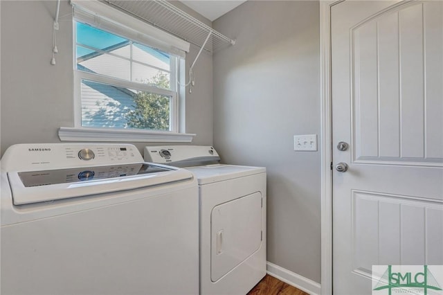 laundry room with baseboards, wood finished floors, laundry area, and washer and clothes dryer