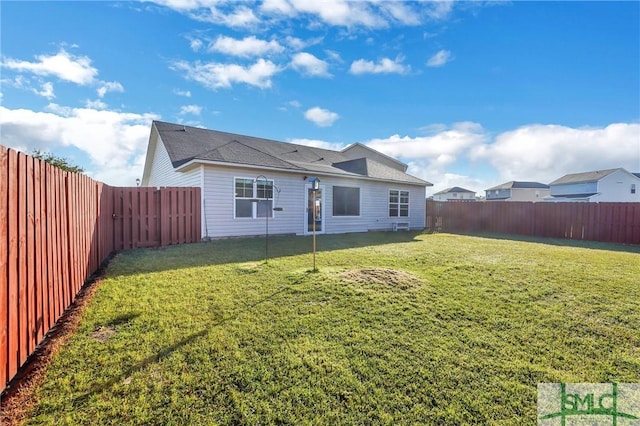 back of property featuring a fenced backyard and a yard