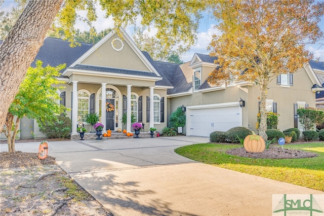 greek revival house with stucco siding, a garage, roof with shingles, and driveway