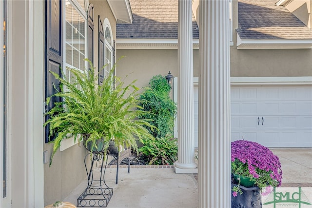 property entrance with stucco siding and a shingled roof