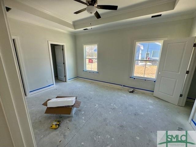 unfurnished bedroom with a tray ceiling, visible vents, and ornamental molding