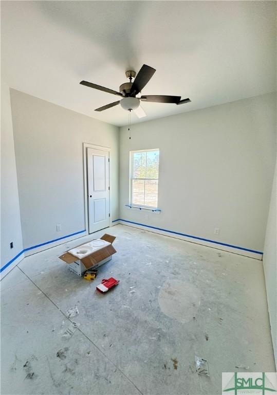 empty room featuring a ceiling fan and baseboards