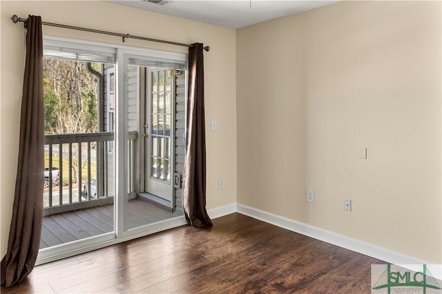 empty room with baseboards and wood finished floors