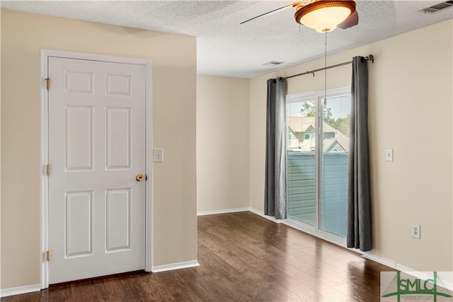 unfurnished room with visible vents, dark wood-type flooring, a textured ceiling, baseboards, and ceiling fan