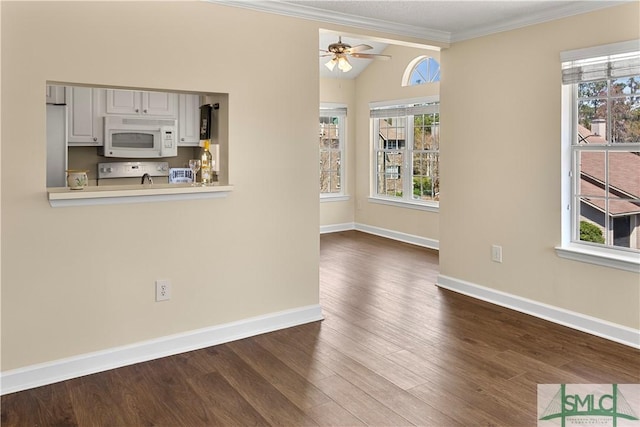 unfurnished dining area with a wealth of natural light, a ceiling fan, dark wood finished floors, and crown molding